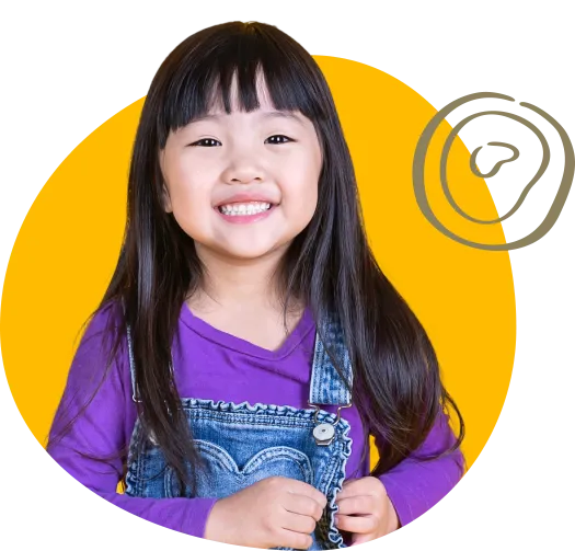 a young child wearing a purple shirt with overalls smiling