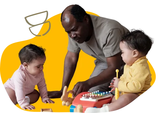 man wearing gray polo shirt playing with toys with infants to his left and right