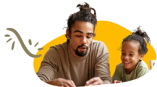 Adult wearing brown shirt and child wearing green shirt looking at an item in front of them.