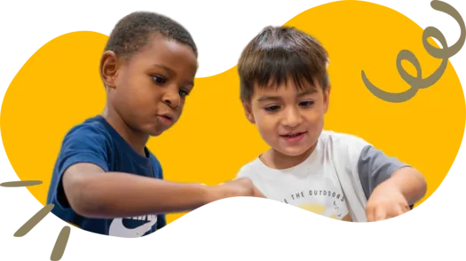 two children next to each other looking at an object in front of them