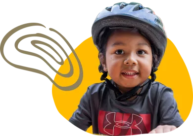child smiling wearing a bike helmet and black shirt